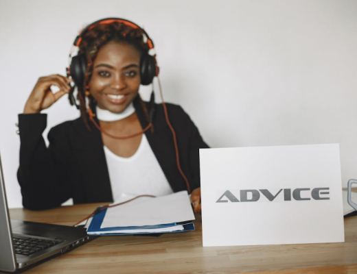 Smiling Woman with an "Advice" Sign Sitting in Front of Her